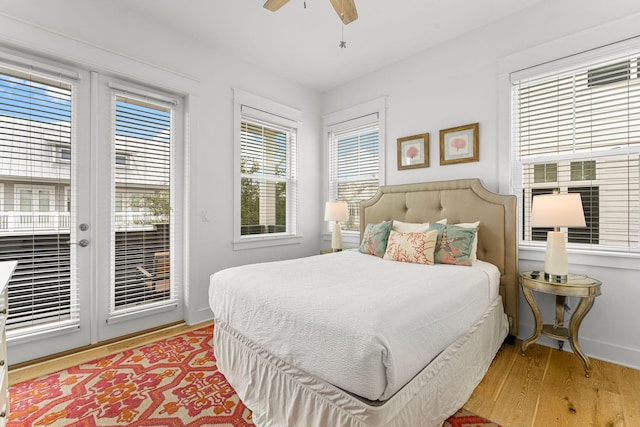 bedroom with multiple windows, access to exterior, and hardwood / wood-style flooring