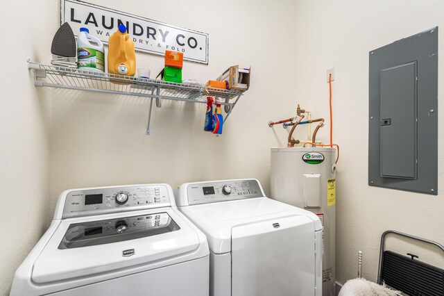 clothes washing area featuring electric panel, washer and clothes dryer, and electric water heater