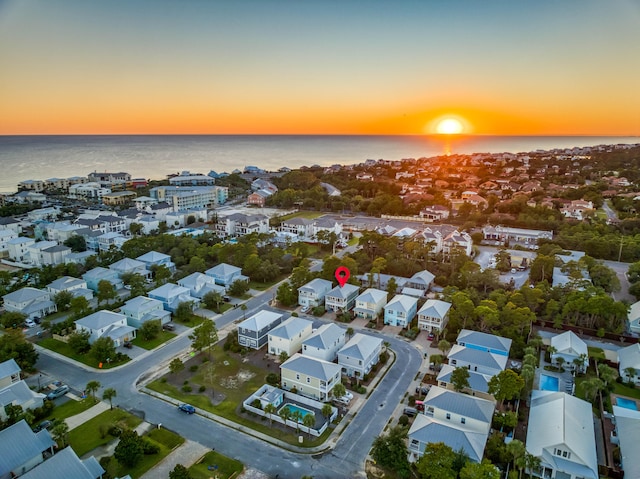 aerial view at dusk featuring a water view