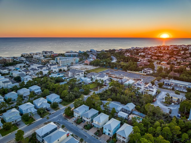 aerial view at dusk featuring a water view