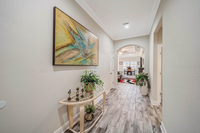 hallway with light wood-type flooring and ornamental molding