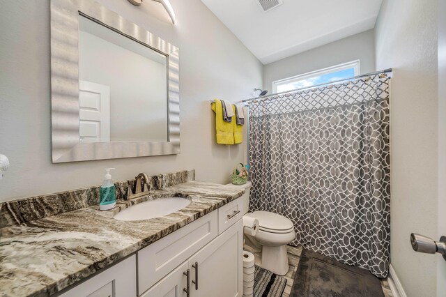 bathroom with vaulted ceiling, curtained shower, vanity, toilet, and tile patterned floors