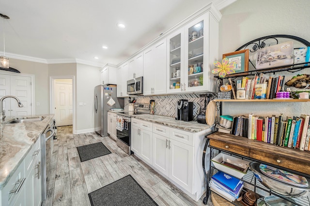 kitchen with appliances with stainless steel finishes, sink, and white cabinetry