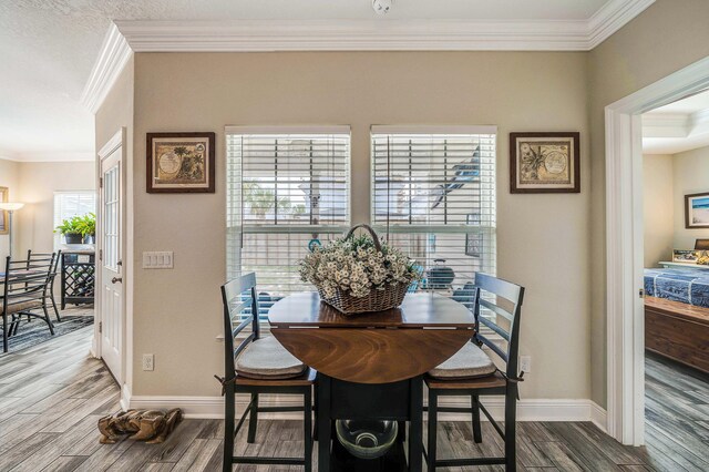 dining area with ornamental molding and hardwood / wood-style floors