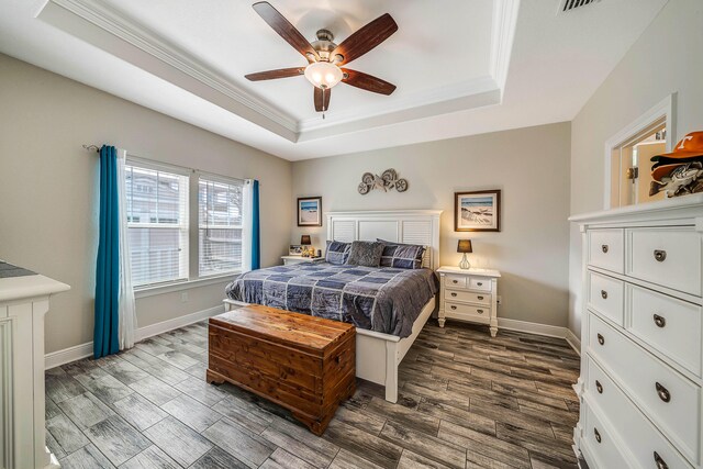 bedroom featuring ceiling fan, a raised ceiling, hardwood / wood-style floors, and crown molding