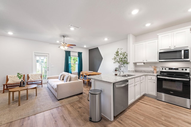 kitchen with stainless steel appliances, white cabinetry, ceiling fan, and light wood-type flooring