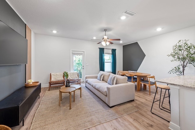 living room featuring ceiling fan and light hardwood / wood-style flooring