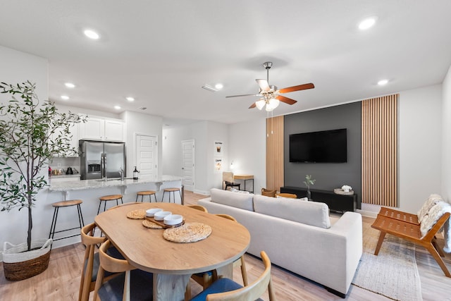 dining space with light wood-type flooring and ceiling fan