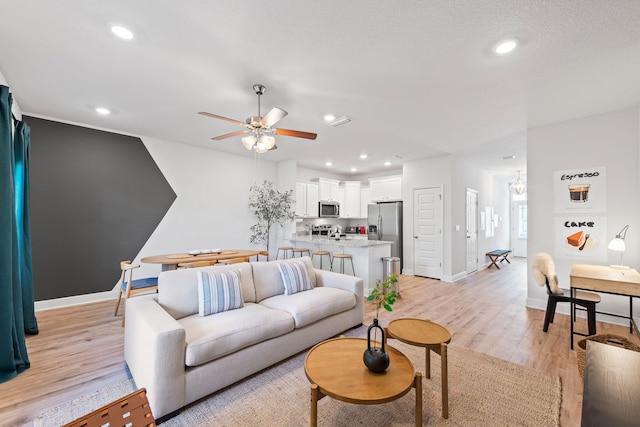 living room with light wood-type flooring and ceiling fan