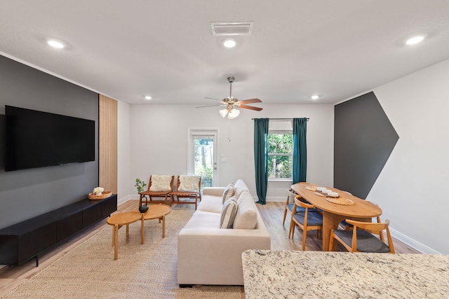 living room with ceiling fan and light wood-type flooring