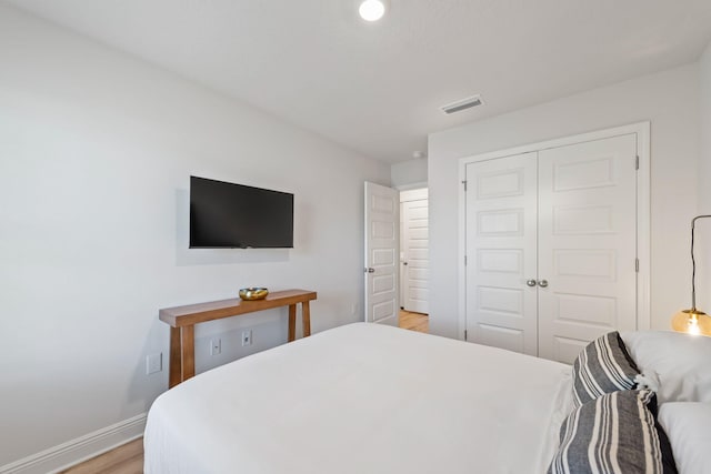 bedroom with a closet and light hardwood / wood-style floors