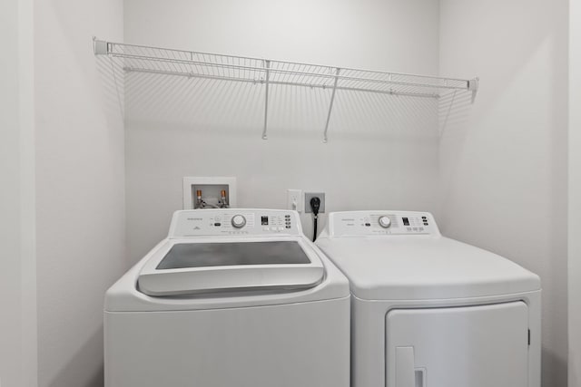 clothes washing area with separate washer and dryer