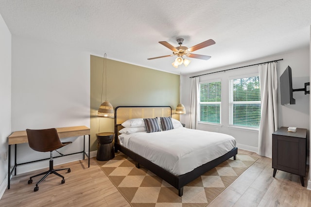 bedroom featuring a textured ceiling, light hardwood / wood-style floors, and ceiling fan