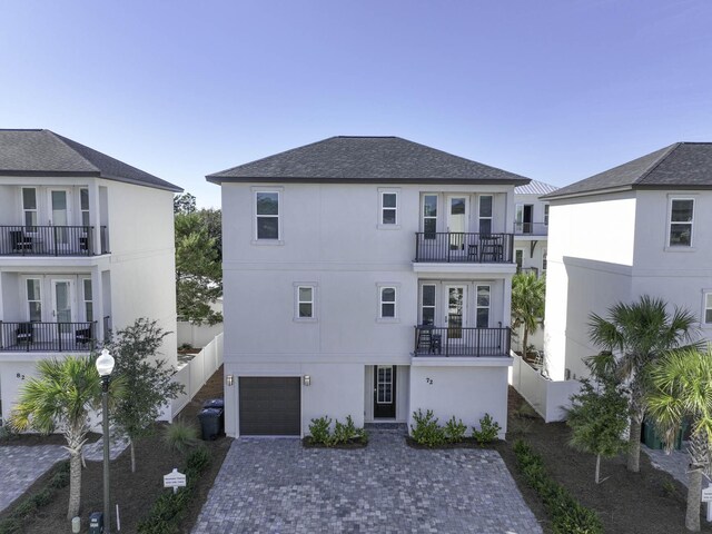 back of property featuring a balcony and a garage