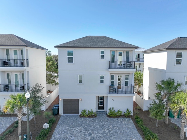 back of property with a balcony and a garage