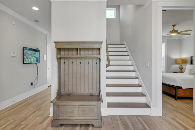 staircase featuring hardwood / wood-style floors and ceiling fan