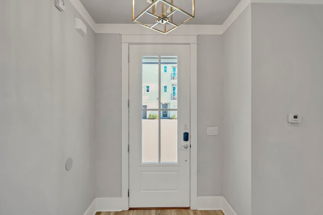 doorway to outside with a notable chandelier and light hardwood / wood-style floors