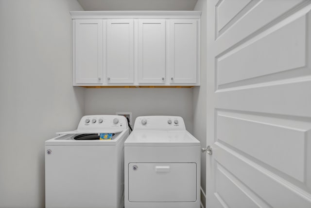 clothes washing area with cabinets and independent washer and dryer