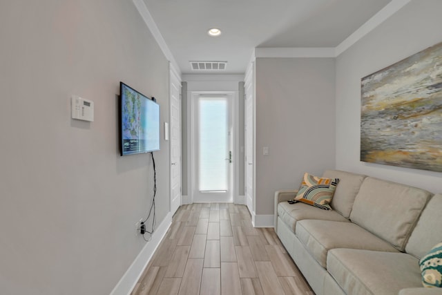 living room featuring light hardwood / wood-style flooring and crown molding