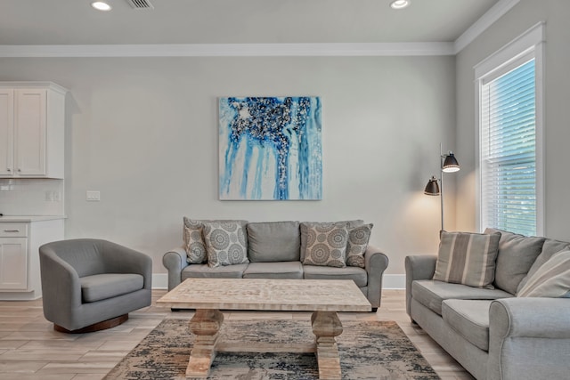 living room with crown molding, light hardwood / wood-style floors, and a wealth of natural light