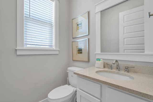 bathroom with vanity, toilet, and a wealth of natural light