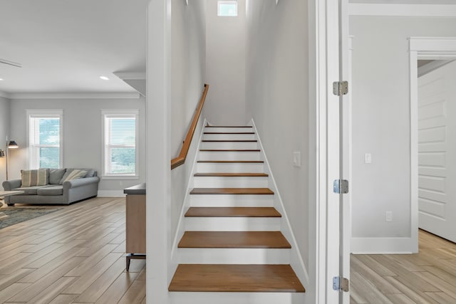 stairway featuring ornamental molding and hardwood / wood-style floors