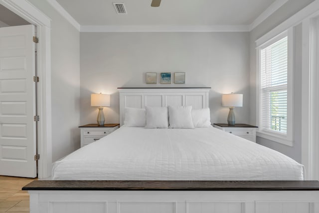 tiled bedroom featuring ceiling fan, ornamental molding, and multiple windows