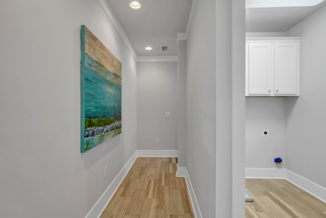 corridor with light wood-type flooring and ornamental molding