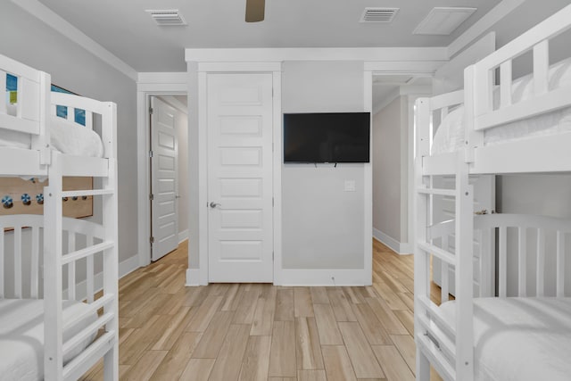 bedroom with light hardwood / wood-style flooring, a closet, ceiling fan, and crown molding