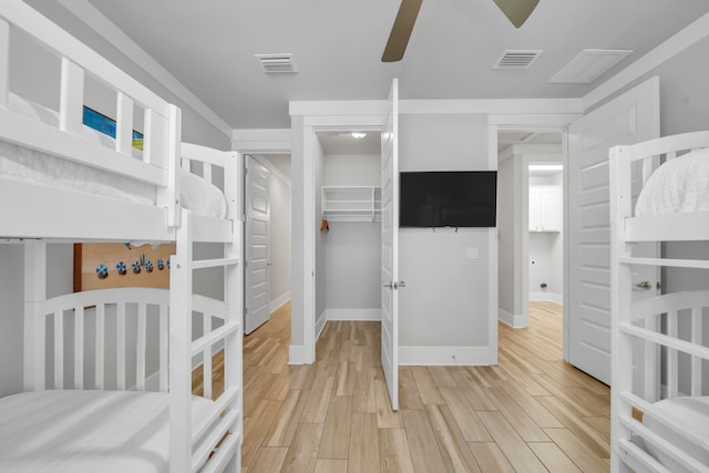 bedroom with light hardwood / wood-style floors, ceiling fan, and a closet