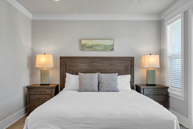 bedroom featuring ornamental molding and light hardwood / wood-style flooring