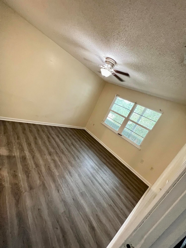 bonus room featuring ceiling fan, a textured ceiling, lofted ceiling with skylight, and dark hardwood / wood-style flooring