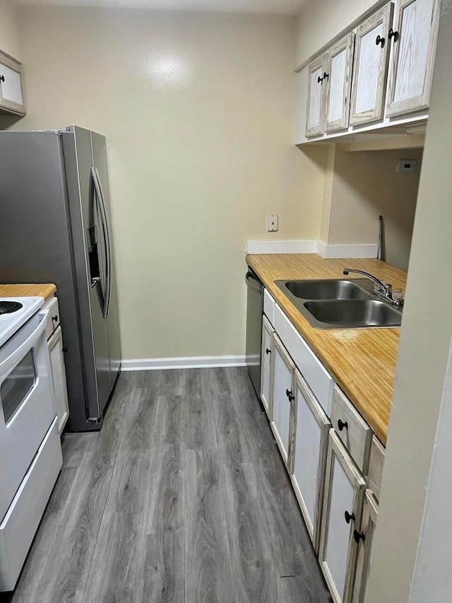 kitchen featuring hardwood / wood-style floors, stainless steel dishwasher, electric stove, and sink