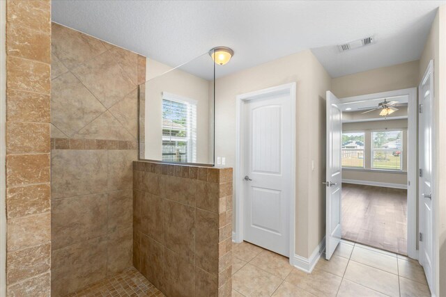 bathroom with hardwood / wood-style flooring, a tile shower, ceiling fan, and plenty of natural light