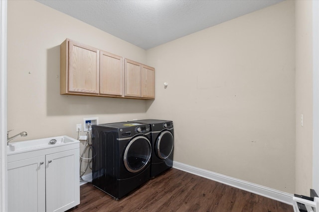 laundry room with cabinets, dark hardwood / wood-style floors, sink, and washer and dryer