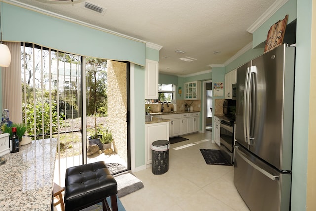 kitchen featuring tasteful backsplash, sink, white cabinetry, appliances with stainless steel finishes, and ornamental molding