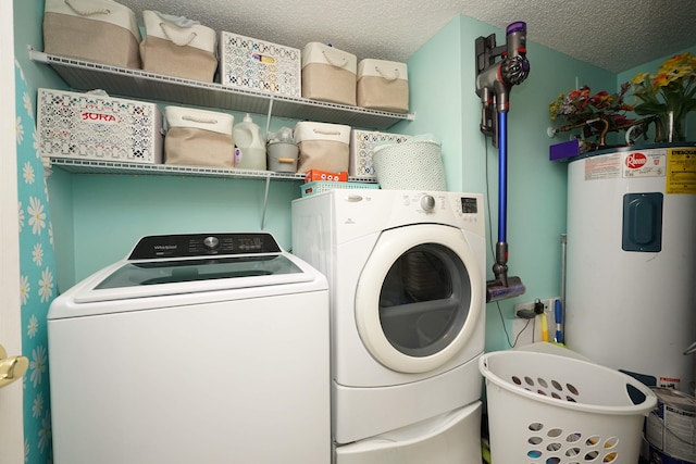 clothes washing area with water heater, a textured ceiling, and separate washer and dryer