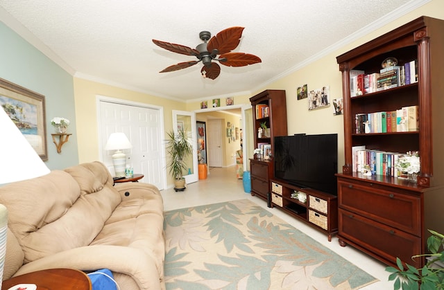 living room with a textured ceiling, ornamental molding, and ceiling fan