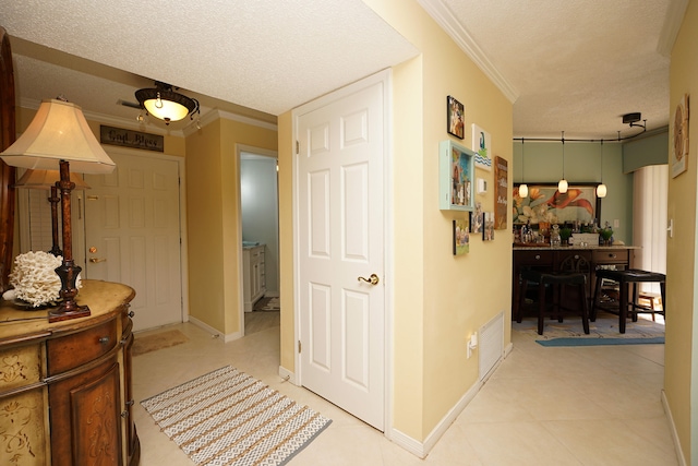 hall featuring a textured ceiling and ornamental molding