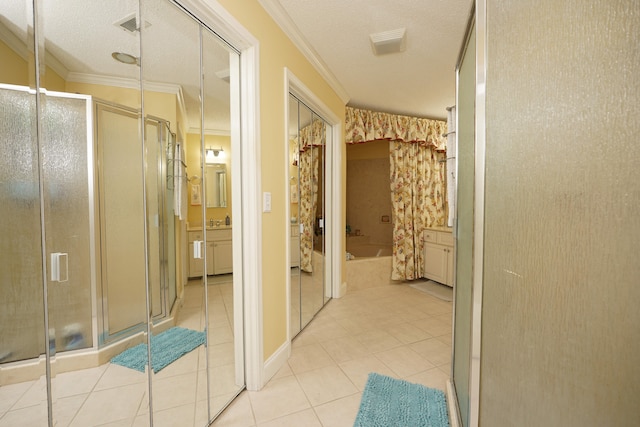 interior space with a textured ceiling, crown molding, and light tile patterned floors