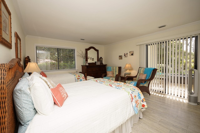 bedroom featuring light hardwood / wood-style floors, access to exterior, and crown molding