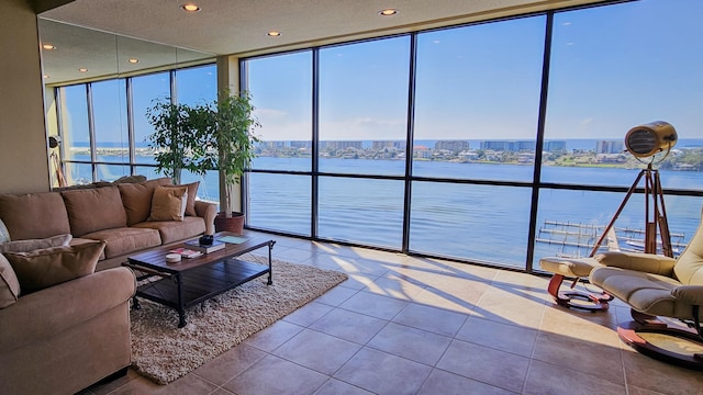 tiled living room with a wall of windows and a water view