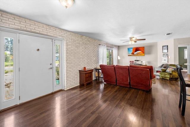 living room with dark hardwood / wood-style flooring, plenty of natural light, and ceiling fan