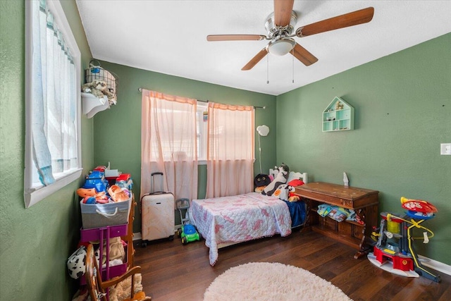 bedroom featuring dark hardwood / wood-style flooring, multiple windows, and ceiling fan