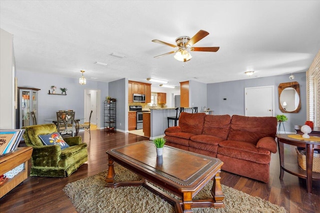 living room featuring ceiling fan and dark hardwood / wood-style floors