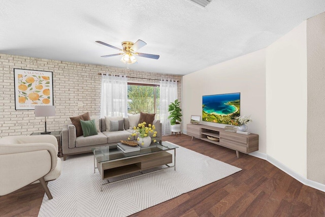 living room with ceiling fan, dark wood-type flooring, a textured ceiling, and brick wall