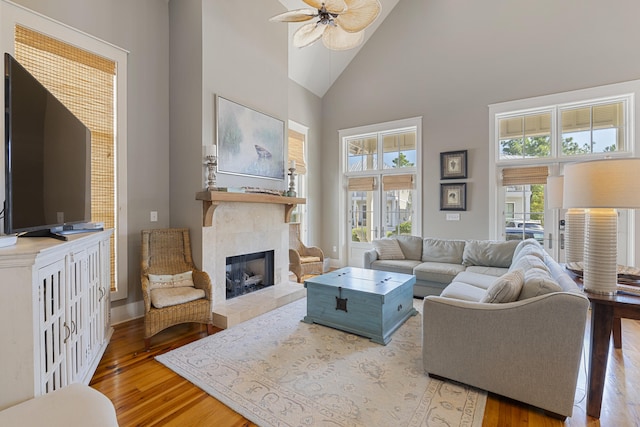 living room featuring ceiling fan, a tile fireplace, high vaulted ceiling, and a healthy amount of sunlight