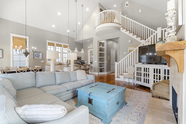 living room featuring an inviting chandelier, a fireplace, hardwood / wood-style floors, and high vaulted ceiling