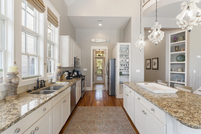 kitchen featuring appliances with stainless steel finishes, plenty of natural light, sink, and white cabinetry