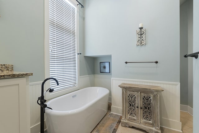 bathroom featuring vanity, tile patterned flooring, and a washtub